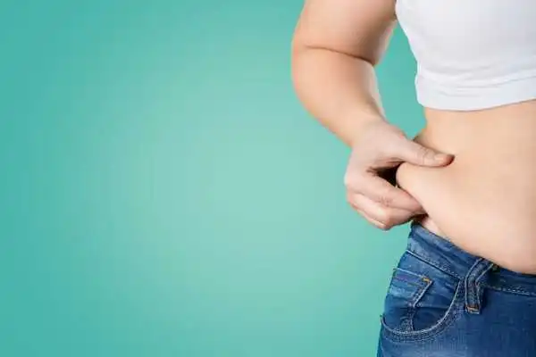Image of woman pinching her love handles to show weight gain Selston
